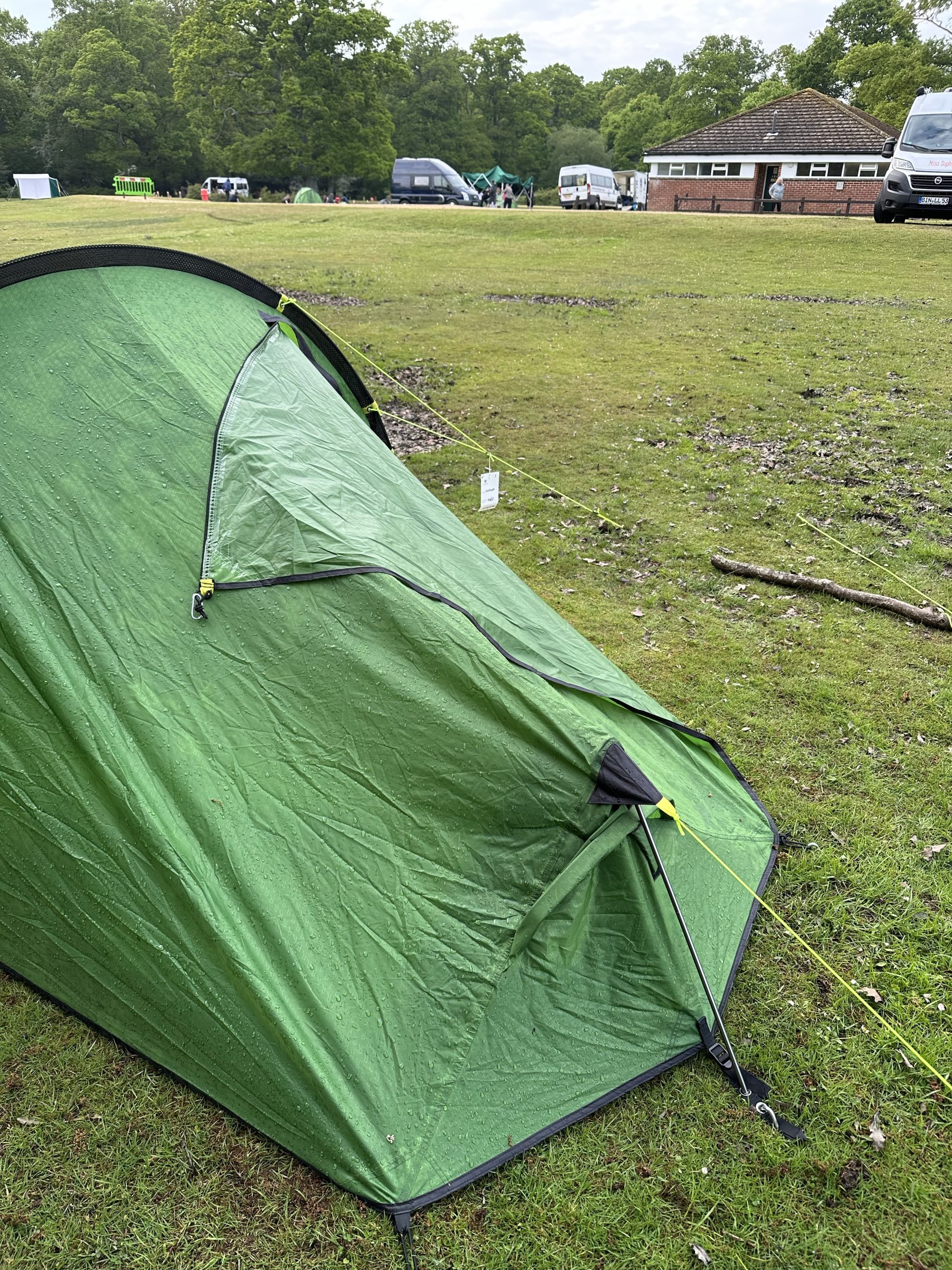 Rain covered green tent in a field